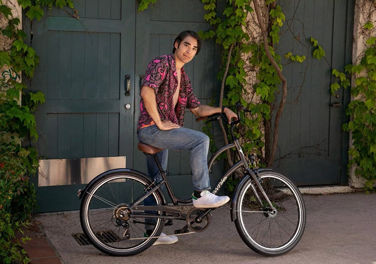 man sitting on a black electra townie 7d cruiser bike