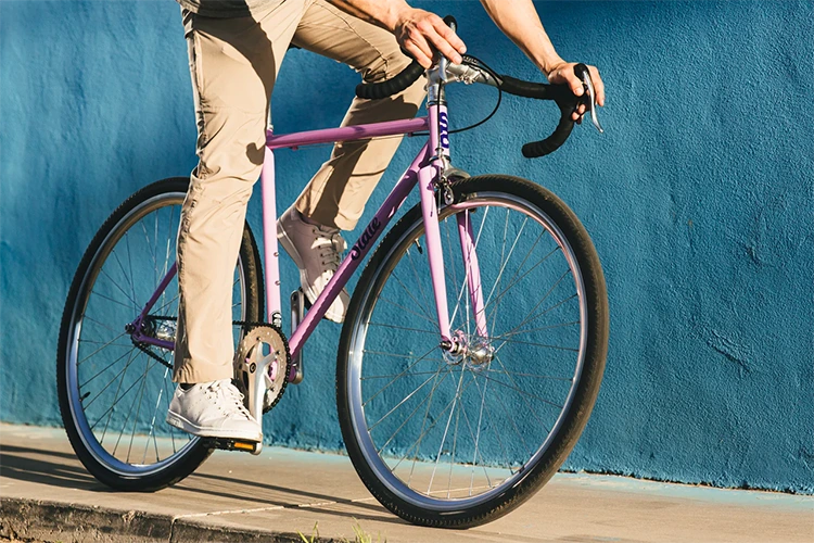 man riding a pink single-speed bike