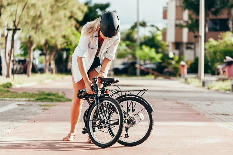 woman in white shirt with a folding bike