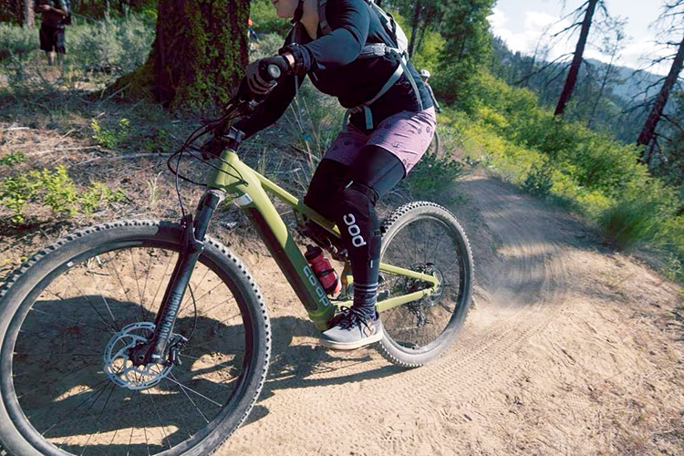 woman riding a co-op cycles electric mountain bike