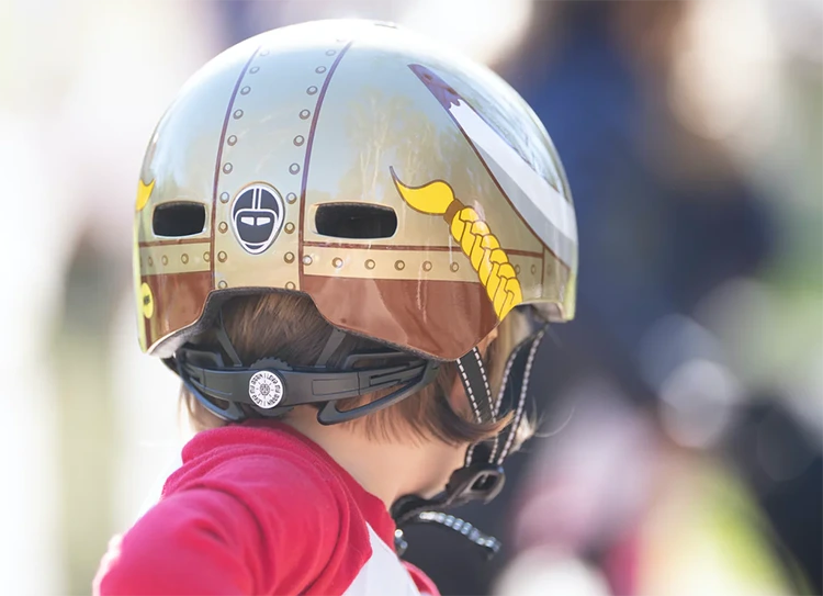 a rear view of a child wearing a nutcase bike helmet