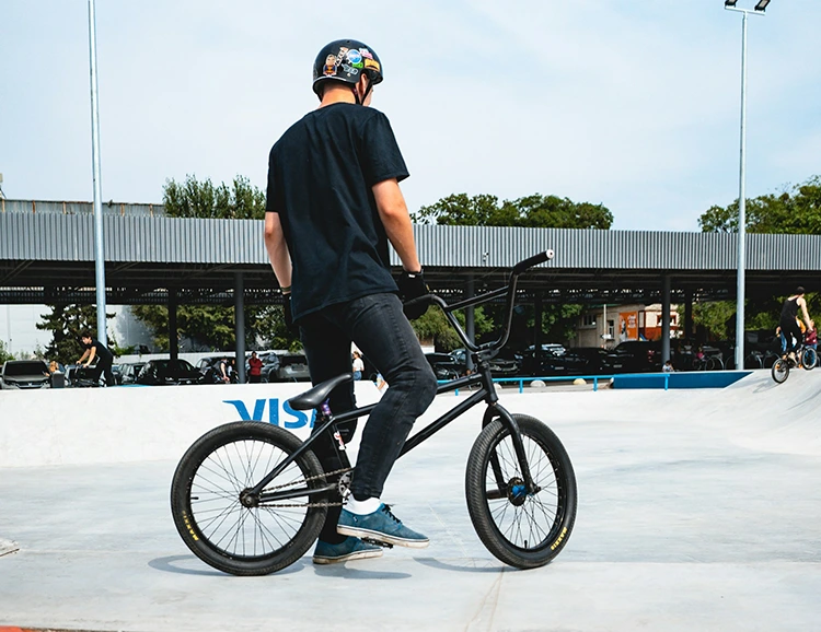 man standing next to a black bmx bike