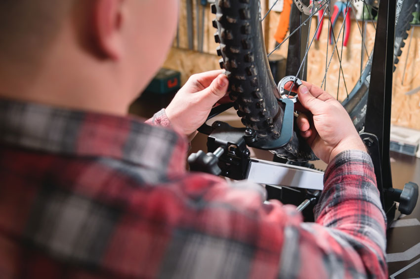 man truing a bike wheel