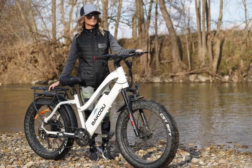 woman standing next to a white bakcou electric bike