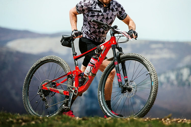 man pushing a red Giant best mountain bike