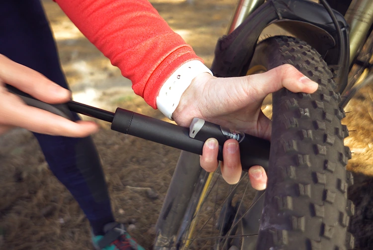 man pumping a tire with a mini bike pump