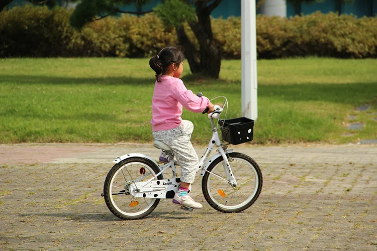girl riding a white kids bike