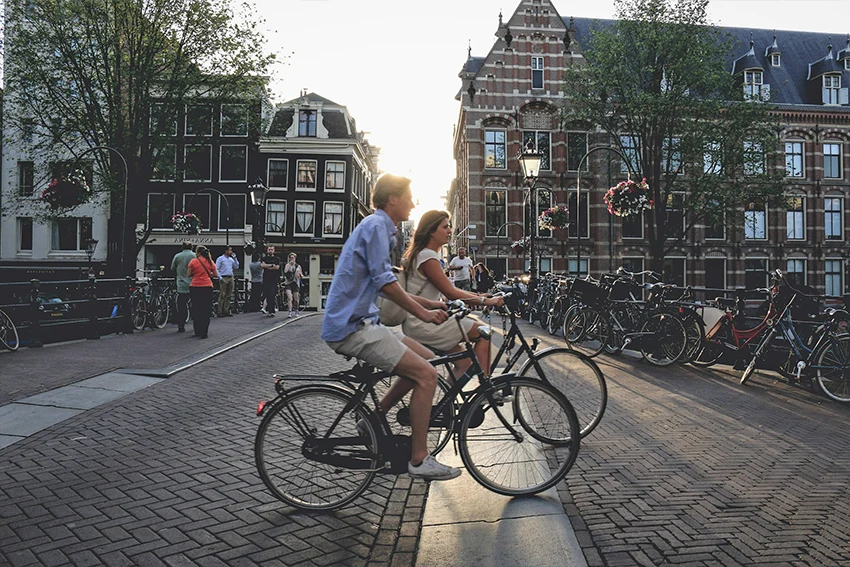 man and woman riding Dutch bikes on Amsterdam streets