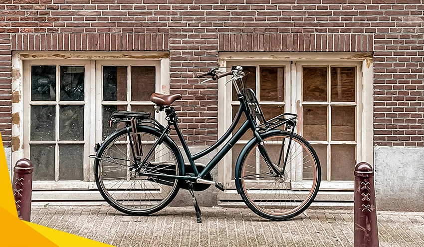 black dutch bike against a brick wall