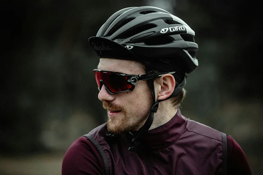 male cyclist wearing a cycling cap and helmet to prevent helmet hair