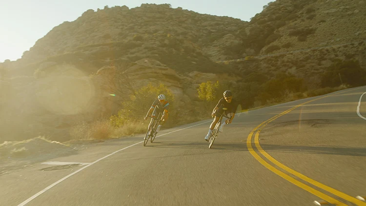 men riding road bikes at sunset
