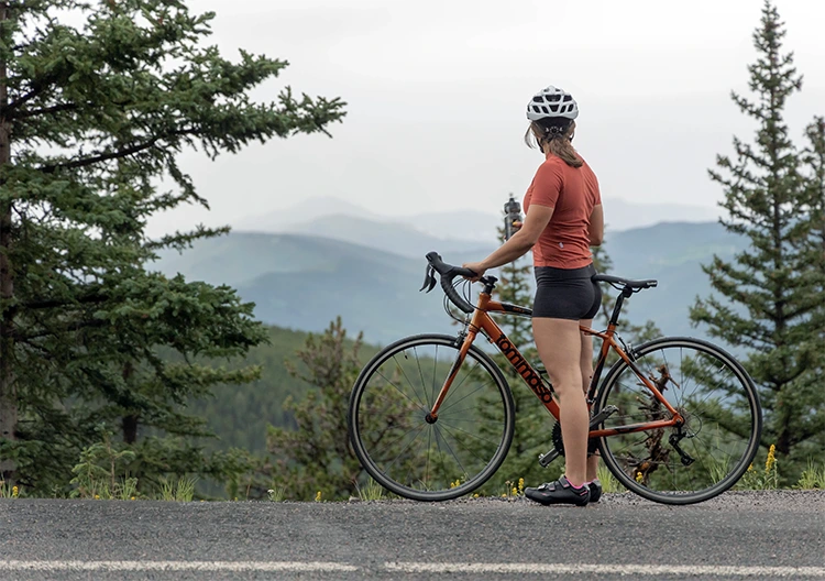 woman standing next to a tommaso road bike