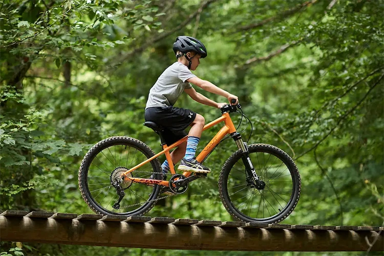 boy riding a vaast mountain bike over a wooden bridge