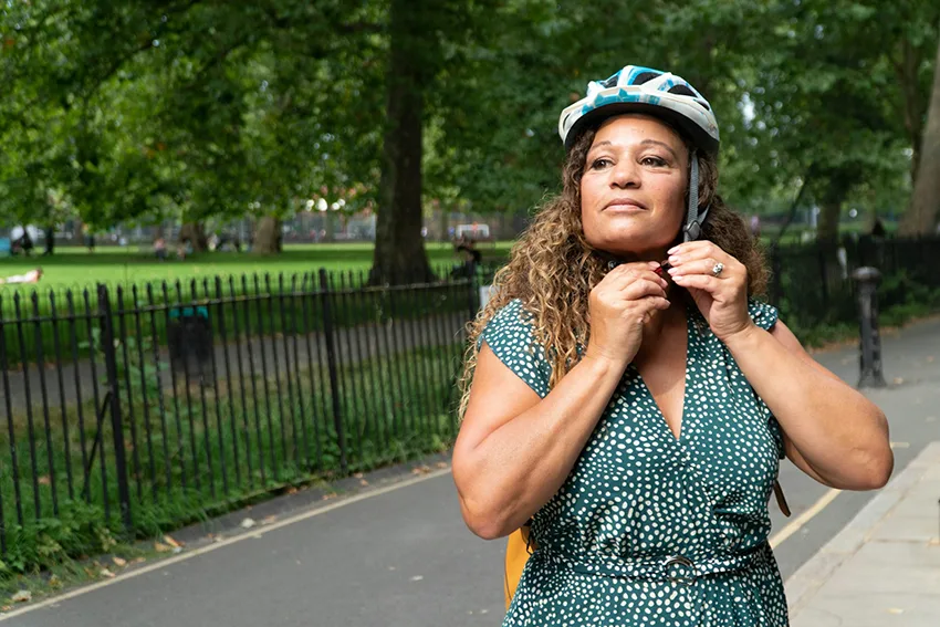 woman with curly hair wearing a cycling helmet