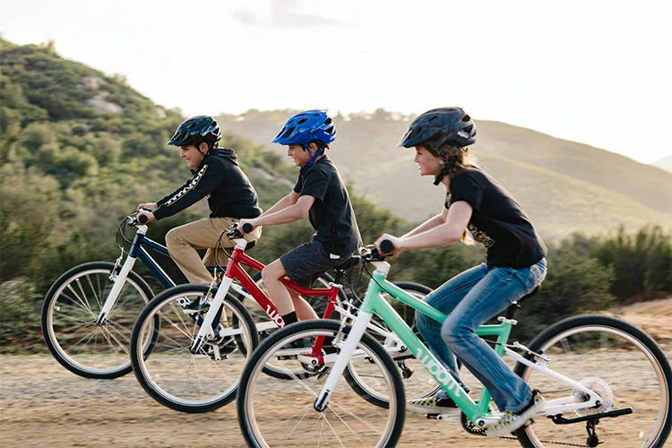 three kids riding woom bikes