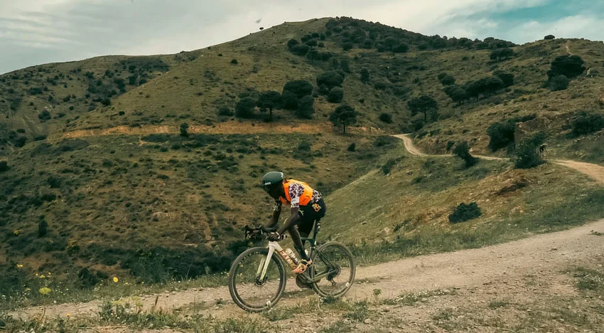 man riding factor ostro gravel bike on a dirt road