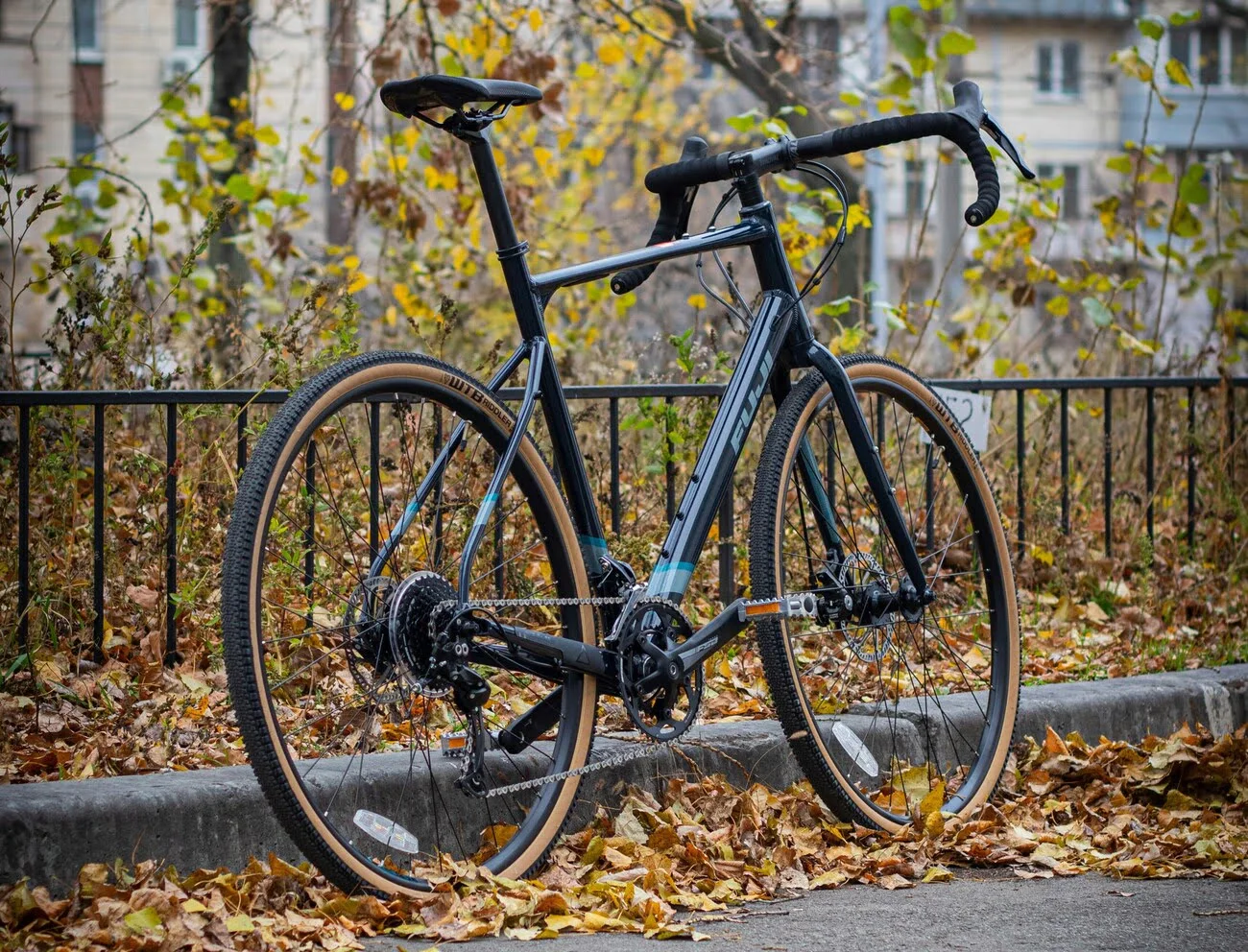 gravel bike with sporty geometry leaned against a fence